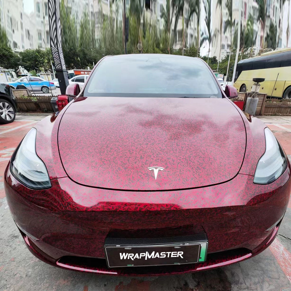 Tesla Model Y wrapped in red forged carbon vinyl, front view with a WRAPMASTER plate