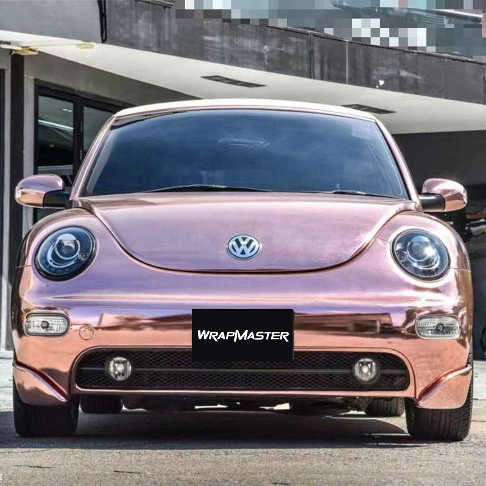 Volkswagen Beetle wrapped in rose gold mirror chrome vinyl, front view, with a WRAPMASTER plate