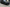 SUV covered in Matte Black color PPF parked on a paved lot outside a glass storefront