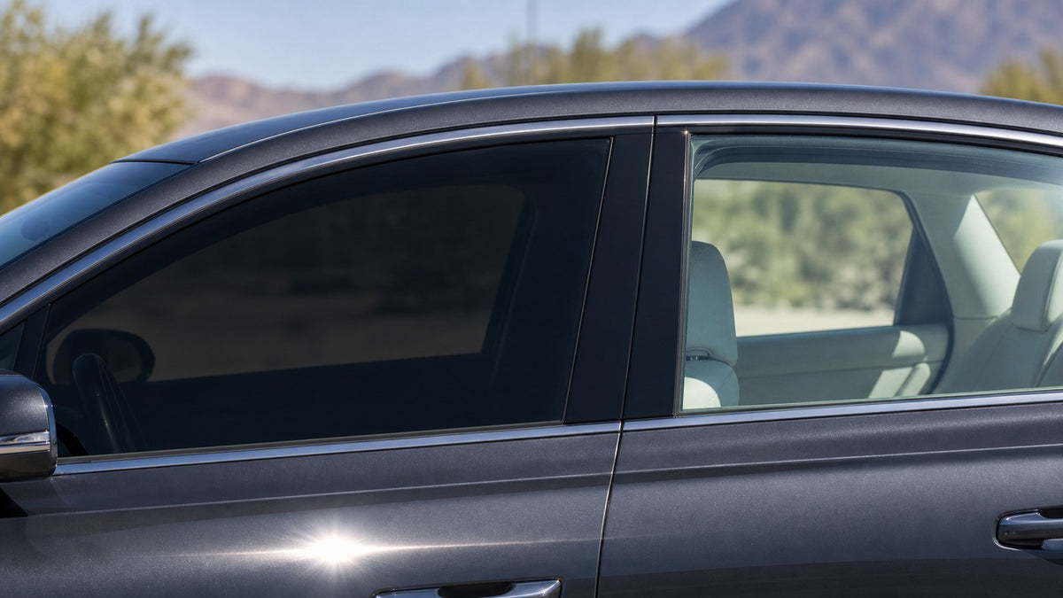 Car side windows in bright sun, the front pane fitted with dark ceramic tint and the rear pane left clear glass so the difference is obvious